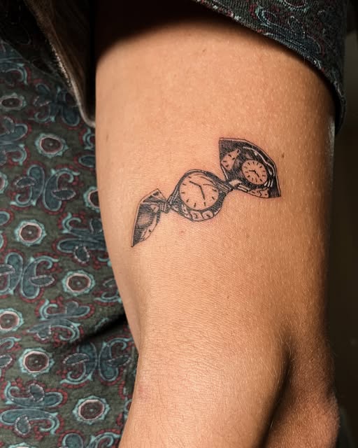 Tatuaje ilustrativo de relojes de bolsillo encadenados, estilo fine-line