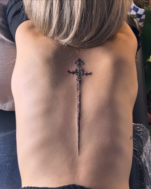 Tatuaje de espada ornamental de línea fina en la columna